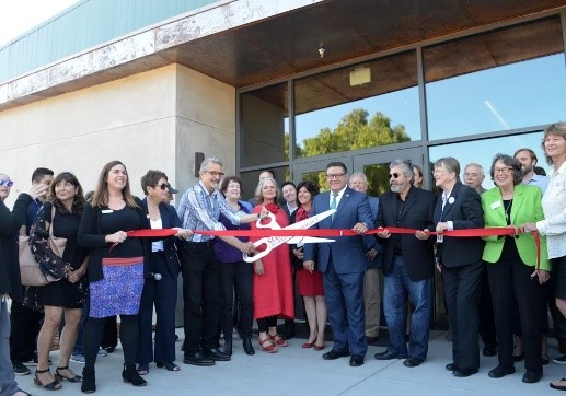 Ribbon cutting with people gathered around